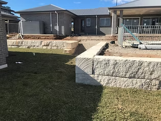 A landscape retaining wall forming level changes across a residential site